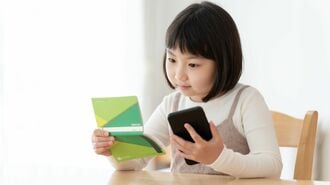 通帳と電卓をとにらめっこする女の子