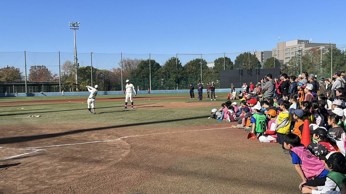 バッティング練習を見学する親子