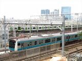 東京総合車両センターの横を通過する京浜東北線の電車（記者撮影）