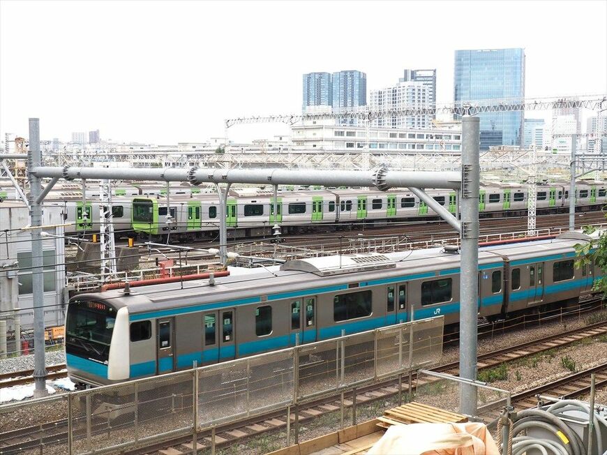 東京総合車両センターの横を通過する京浜東北線の電車（記者撮影）