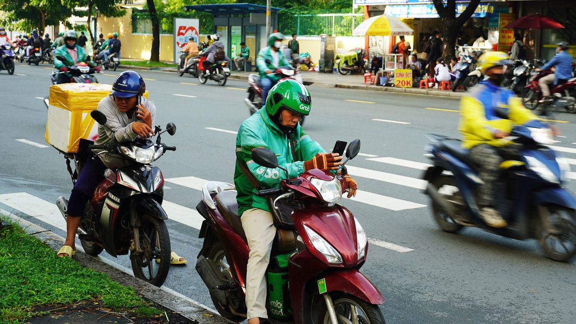 道路の脇で停車して待機するGrabのドライバー