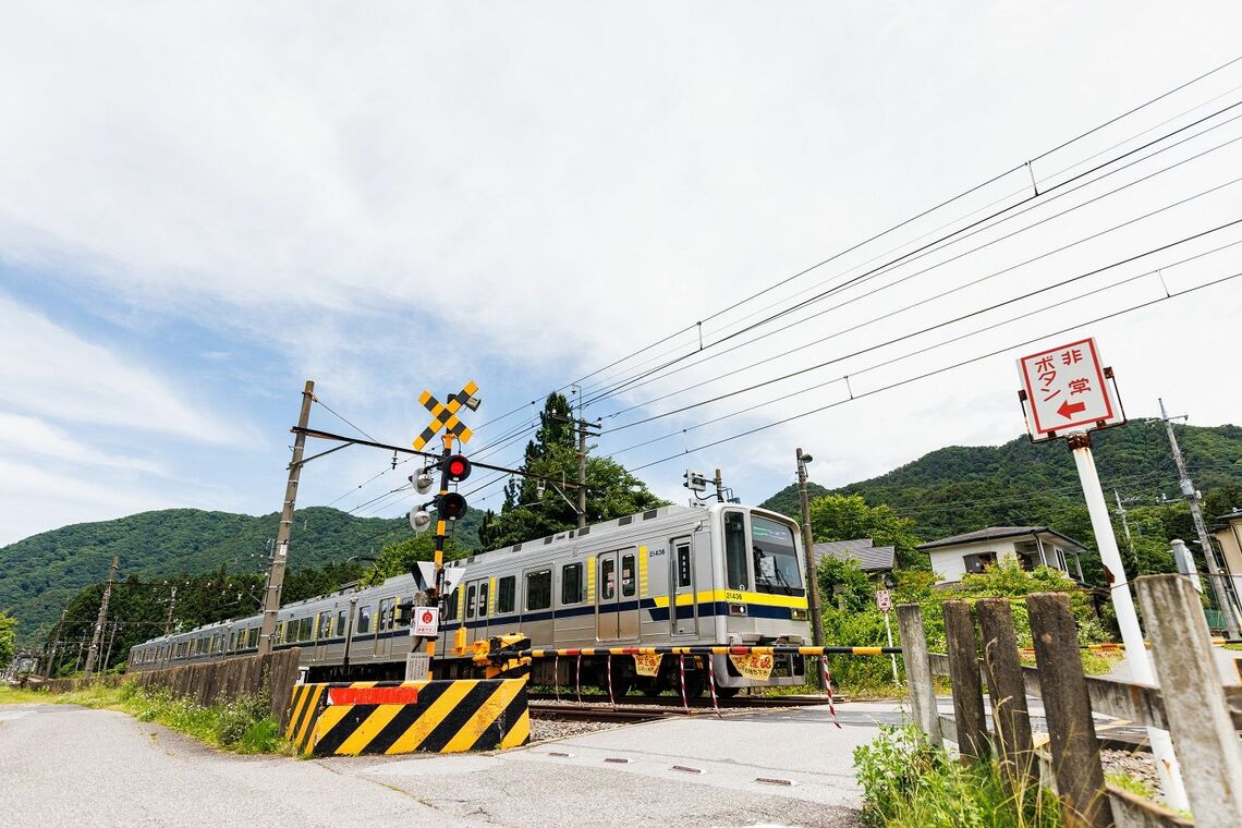 鬼怒立岩信号場付近の踏切を通過する普通列車（撮影：鼠入昌史）