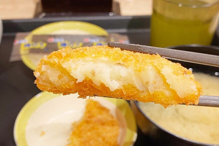 コロッケの断面図。細かくつぶしたなめらかなじゃがいもと、カラッと揚がったパン粉の食感がおいしい（筆者撮影）