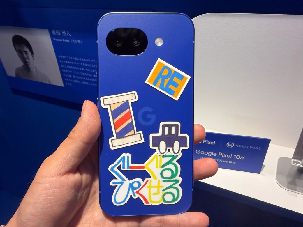 藤田望人氏の作品とステッカーを貼ったイサイブルー。描いたものを切り取りコラージュする作風で知られる（写真：筆者撮影）