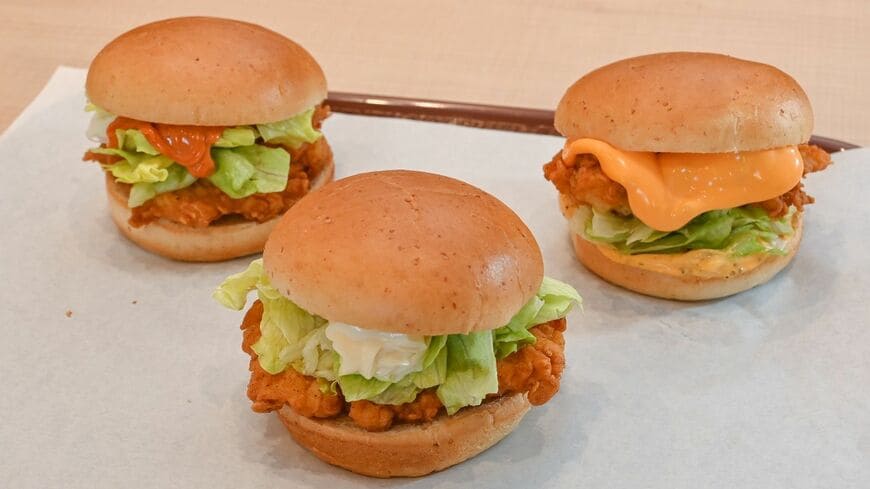 「サンド」から「バーガー」への名称変更とともにメニューを増やして日常利用の強化を狙った、KFCの食事メニュー。中央から左回りに「チキンフィレバーガー」390円、「辛口チキンフィレバーガー」420円、数量限定で発売中の「チーズにおぼれるフィレバーガー」490円。価格はすべて取材時（撮影：大澤誠）