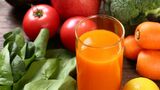 オレンジの野菜ジュースとトマト（写真：taa／PIXTA）