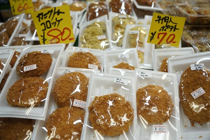 コロナ禍以前はトングで取るスタイルだったコロッケ類も、今は1個・2個入りの小分けパックで並ぶ（写真：筆者撮影）