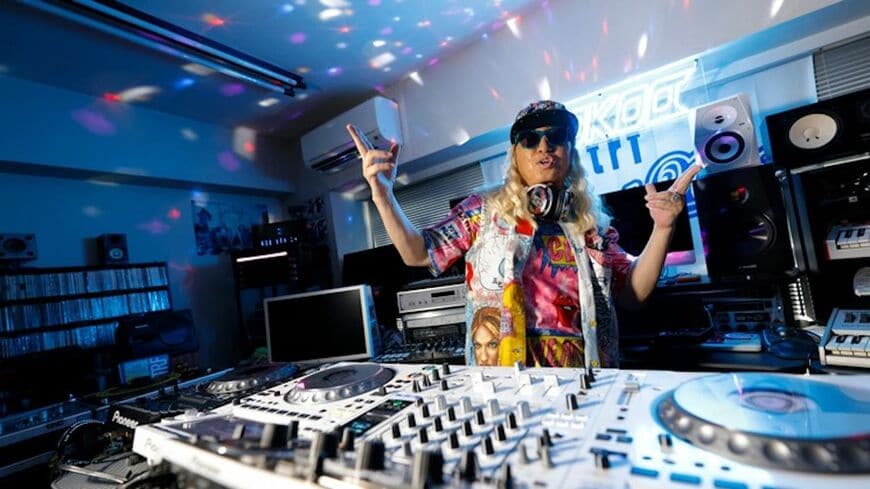 ノリノリで迎えてくれたKOOさん。『EZ DO DANCE』をかけてアゲてくれた。超レアなガジェットがずらり（写真：エンジニアtype編集部）