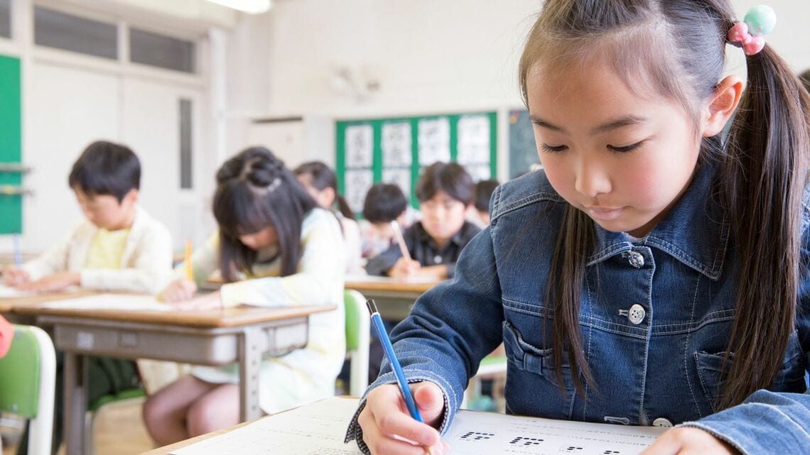 机に向かって勉強する子ども