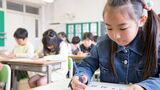 机に向かって勉強する子ども