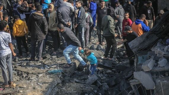 ガザで爆撃により破壊された建物のまわりに集まる人々