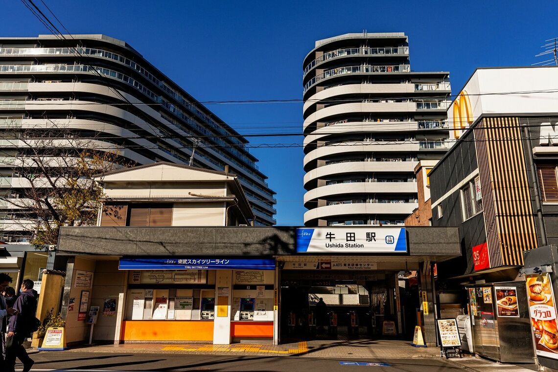 マクドナルドが食い込むように牛田駅の脇にあり、後ろに大きなマンションが建つ（撮影：鼠入昌史）