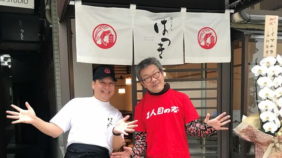 2025年3月24日、「おにぎりはつき」の1人目の客になった涌井さん。店長さん(左)がTシャツと趣味を面白がってくれて、開店前に写真を撮ってくれた(写真:涌井さん提供)