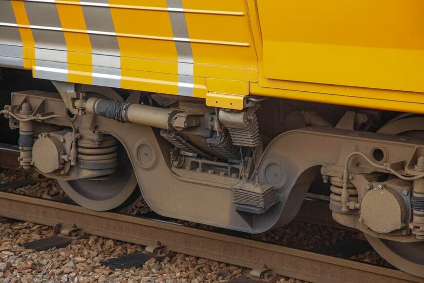 JR四国8000系試作車のベアリングガイド式振り子台車。蛇腹のカバーがある部分がガイドレールで、台車枠にはベアリングボックスが見える（筆者撮影）