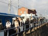 渚駅で電車からバスに乗り継ぐ人々＝2022年1月（記者撮影）
