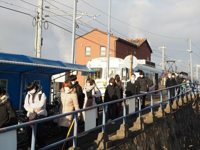 渚駅で電車からバスに乗り継ぐ人々