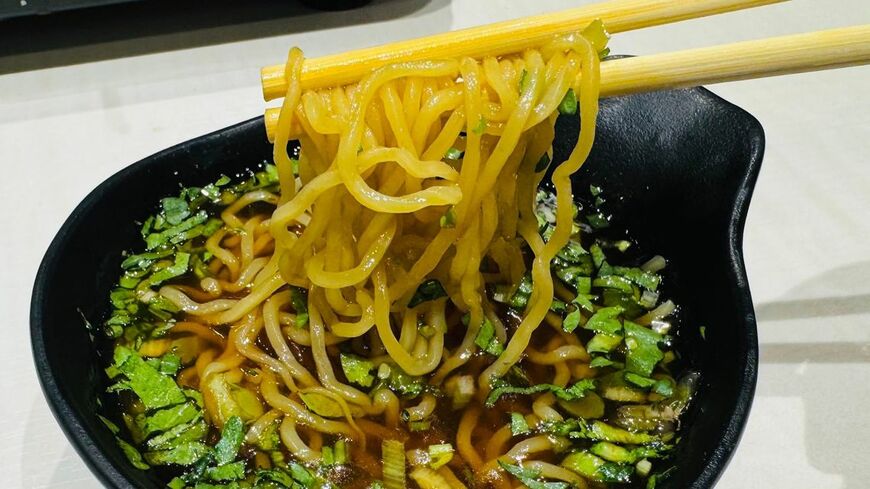〆のつけ麺。西山製麺の縮れ麺を、ラム肉の旨みが溶け込んだタレをほうじ茶で割ったスープで食べる。軽い口当たりで飲みの〆として機能する（写真：筆者撮影）