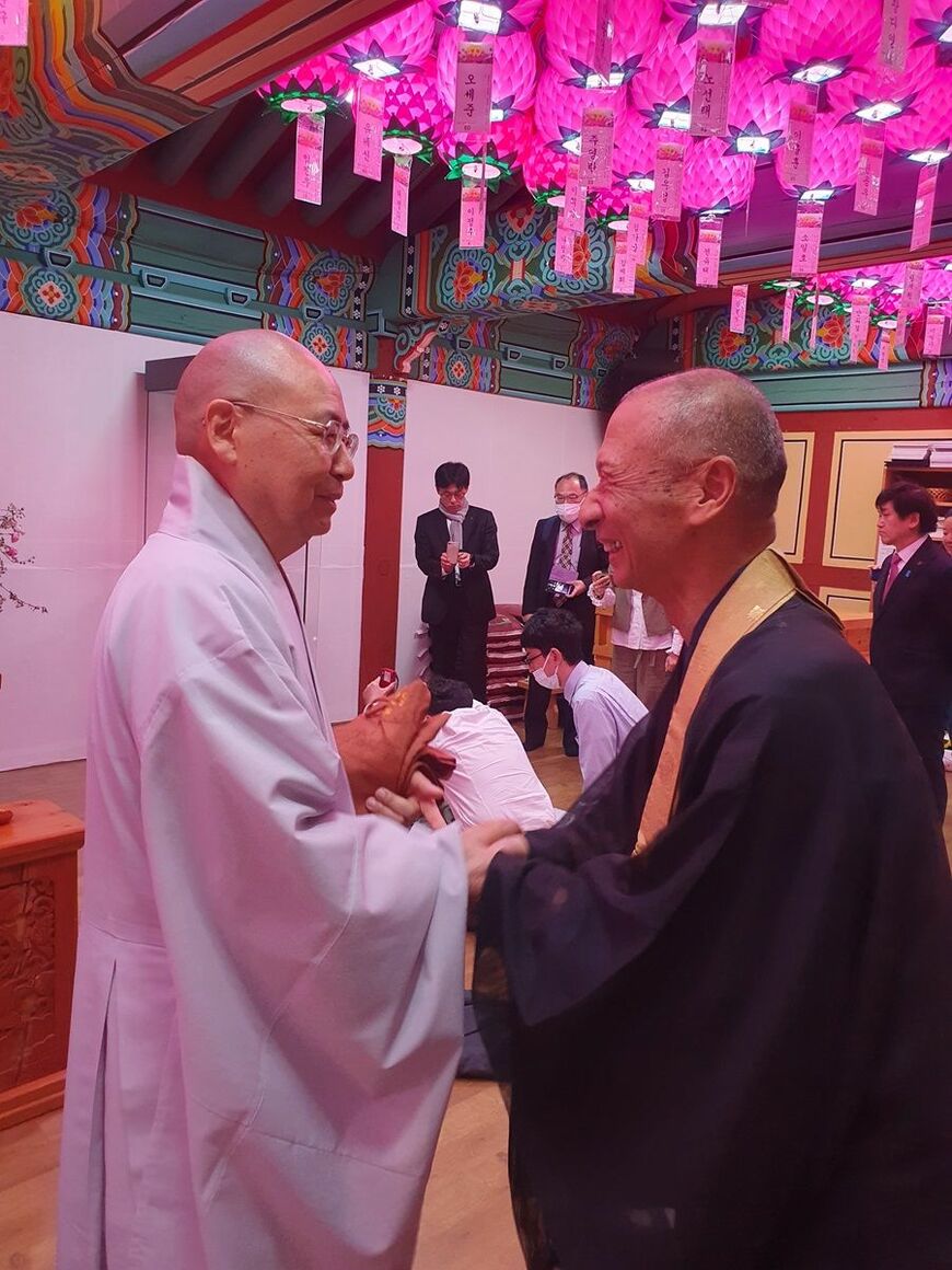 法要後、観音寺の田中前住職（右）は浮石寺の円牛住職へ歩み寄り、手を差し伸べ、握手を求めた（写真：筆者撮影）