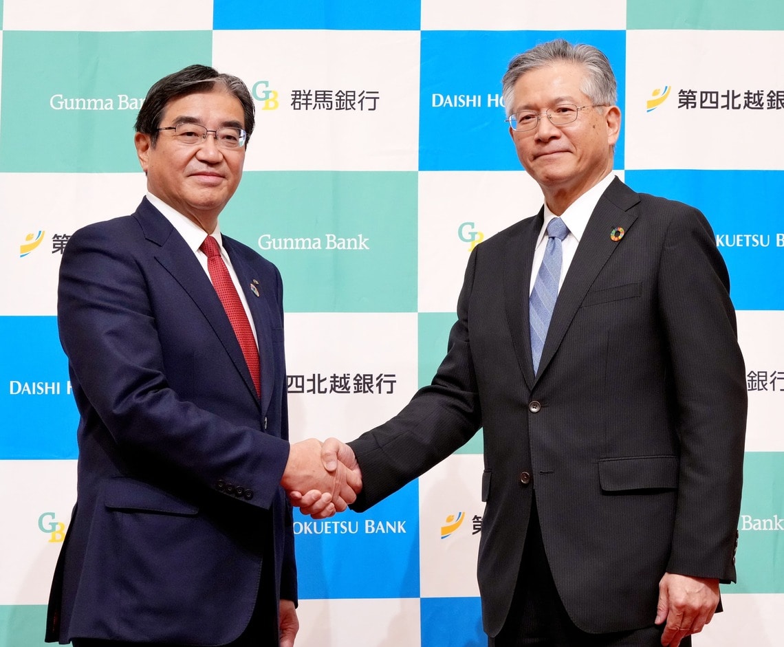握手する深井頭取と殖栗社長