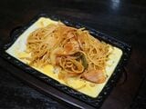 鉄板ナポリタンはサラダ付きで950円。元町本店ではナポリタンの上に生卵を乗せて提供、月見山店では鉄板の下に薄焼き卵を敷く提供方法を採用している。写真は月見山店バージョン（著者撮影）