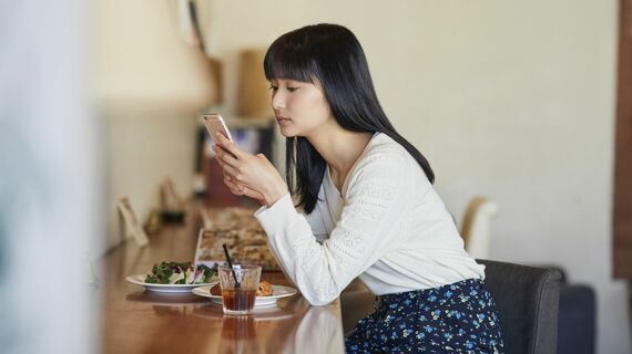 カフェでスマホを見る女性