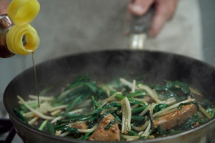 風味づけのごま油もやはり鍋肌からタラ～り（写真：吉澤健太）