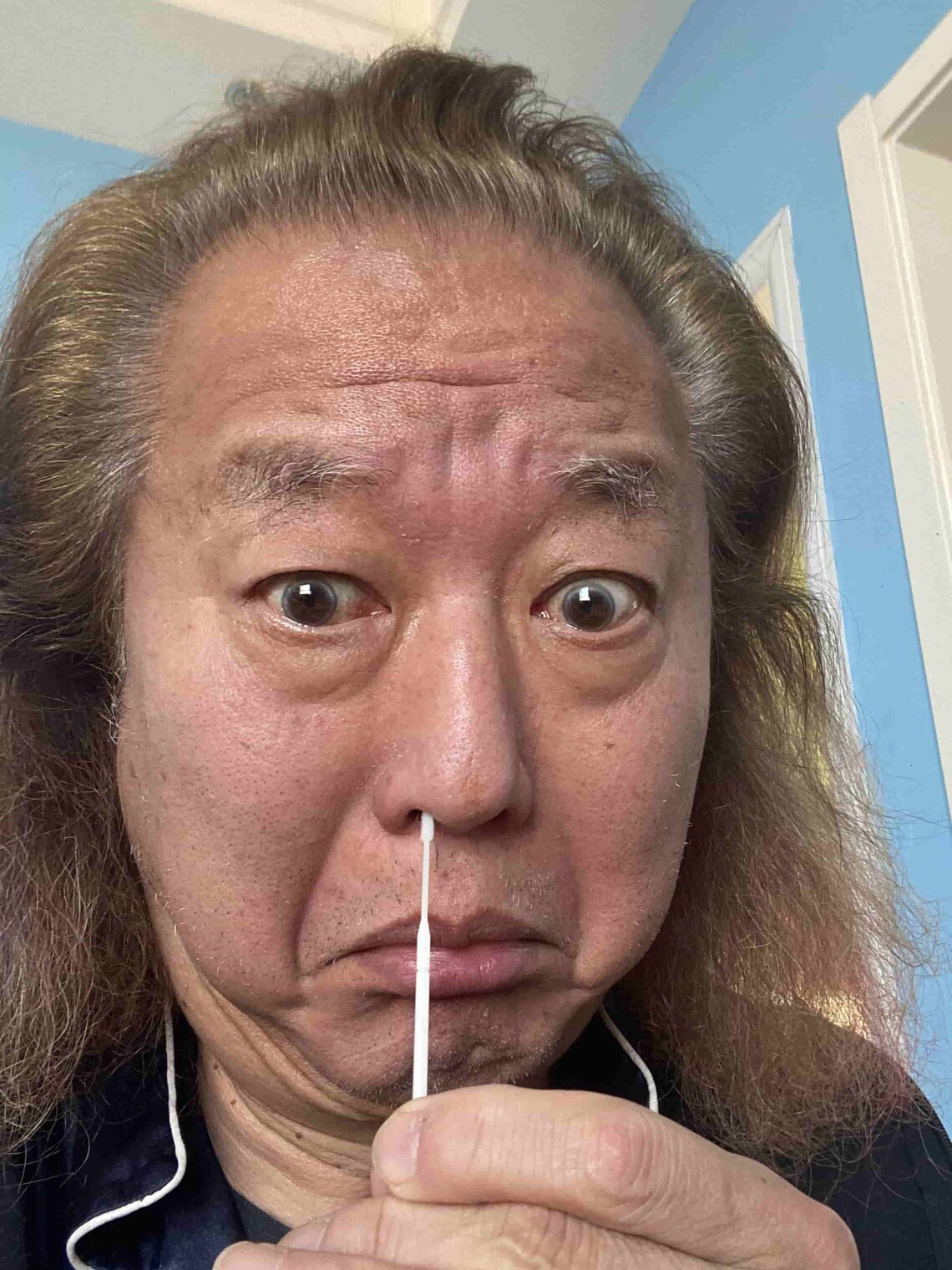 抗原検査キットを使用する筆者。見事に陽性（写真・筆者撮影）