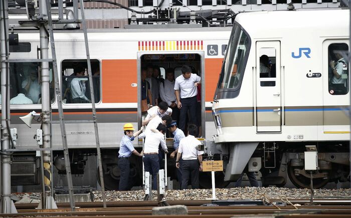 運行中止となった列車から降りる人々