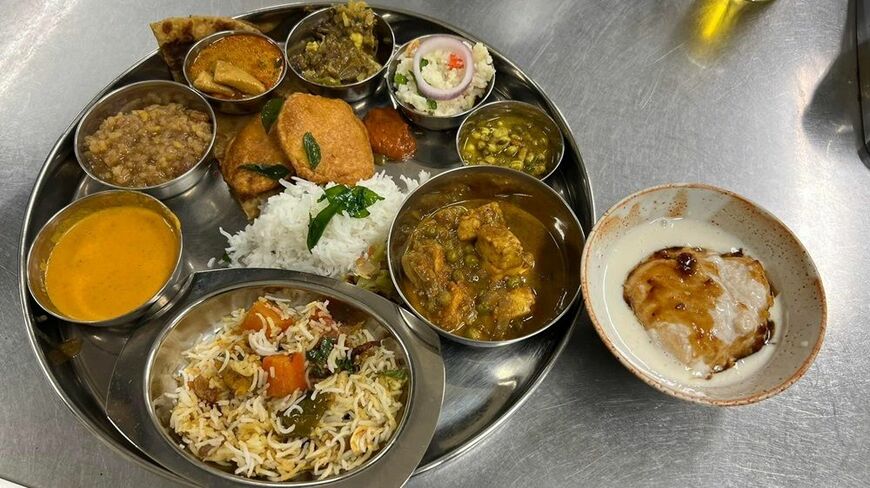 クッキングイベント「Indian Cooking Party」で日本人のカレーマニアが調理し、インド人に振る舞ったベジビリヤニと、6種類のカレーにスナックが添えられたオリジナルターリー（食器提供：アジアハンター、写真：八木さん提供）
