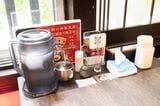 各テーブルにはたっぷりの冷えた水、ミックス塩、葉ニンニク辣油、赤山椒、ティッシュが置かれている（筆者撮影）
