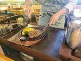 熱々の鉄板に割れ目を押し付け、こうばしく焼いて仕上げる（筆者撮影） 
