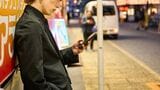 壁に寄りかかっってスマホを触るホスト