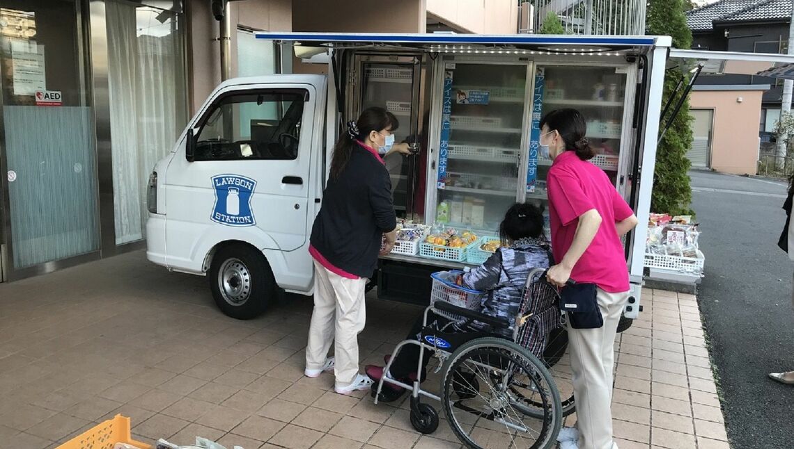 ローソンの移動販売車で買い物をする高齢者施設の入居者（写真：ローソン提供）