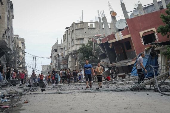 破壊された建物の外にいるパレスチナ人住民。