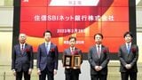 住信SBIネット銀行の上場会見で壇上に立つ円山法昭社長