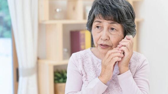 不審な電話に出るシニア女性