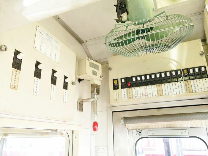 運転室内の扇風機と壁に並ぶスイッチ類