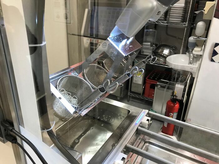 客席側からガラス越しにみたロボット。水を切る