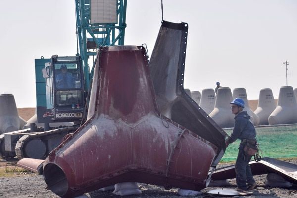 型枠を数枚重ね、特殊な金具で留めていく（記者撮影）