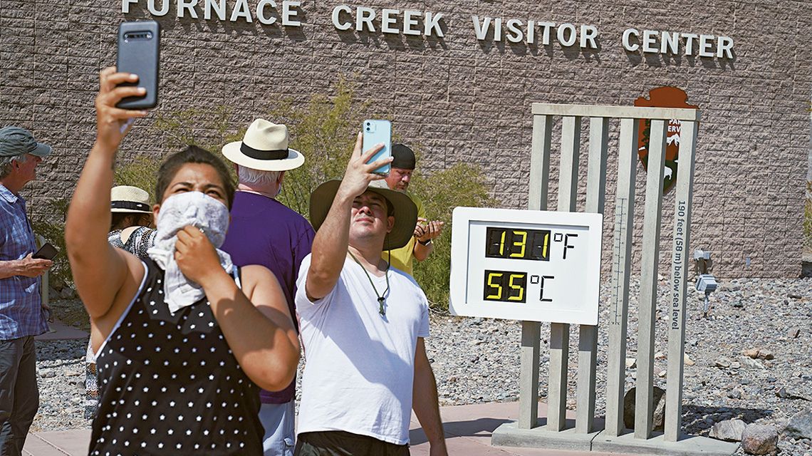 55℃の温度計前で記念撮影する観光客