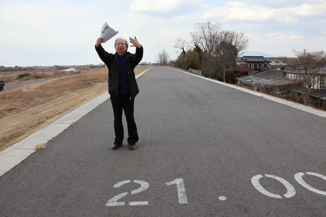 利根川合流地点から21kmの三坂町の上三坂地区。水害後に整備された堤防の上で、当時の状況を説明する原告団共同代表の片倉一美さん（撮影：河野博子）