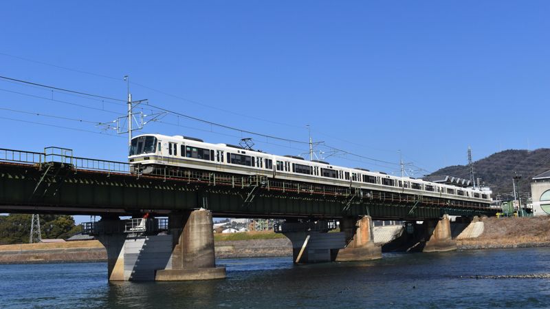 宇治川を跨ぐ橋を行く221系。単線橋梁だったが今回、複線化された区間である（筆者撮影）