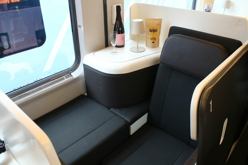 ドイツの新興企業Nox Mobilityによる夜行列車用の座席車「Nox Suites」の座席状態。フルフラットベッドにもなる。テーブル部分は後席の足元が入るスペース（撮影：橋爪智之）