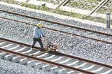 インドネシア高速鉄道建設工事、レールをボルトで固定する作業員