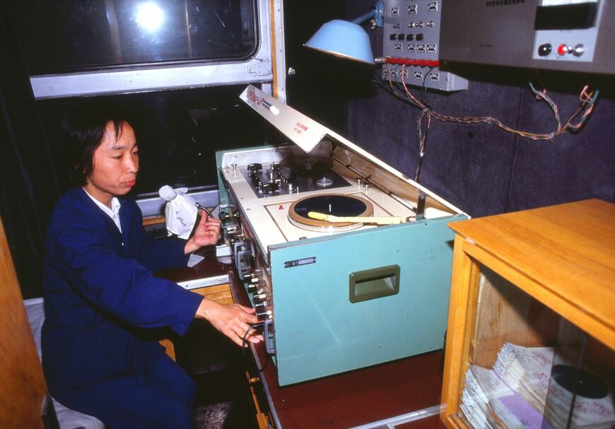 車内でレコードをかけながら放送する「DJ風」の車内放送係員（撮影：南正時）