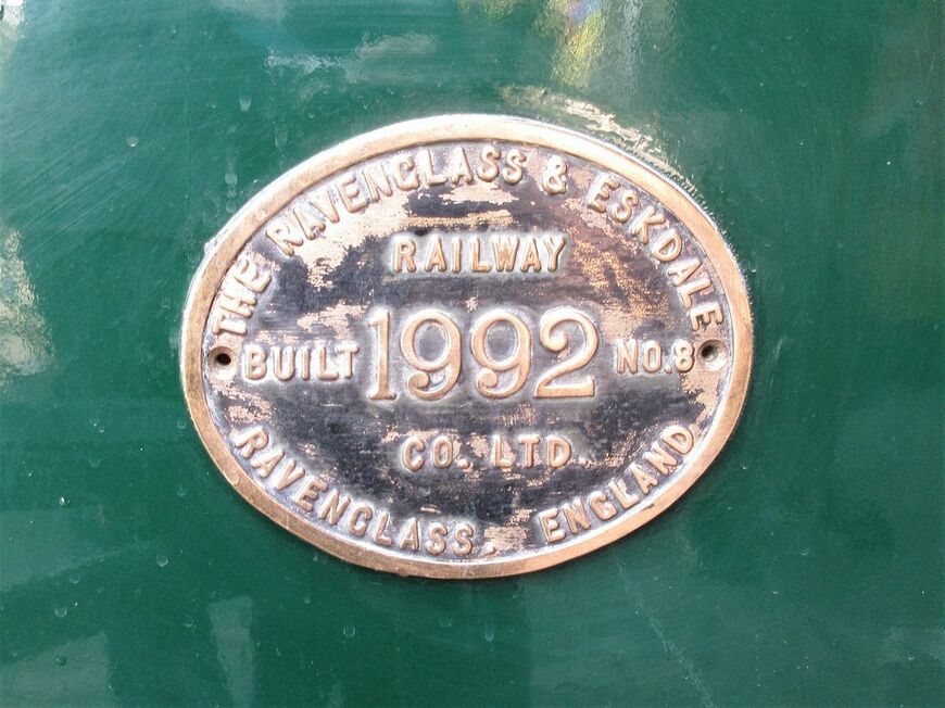 レイブングラス・アンド・エスクデール鉄道から譲り受けた蒸気機関車のプレート。鉄道名と1992年イングランド製の文字が刻まれている（筆者撮影）