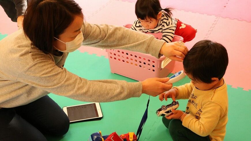 熱を測る保育園の先生