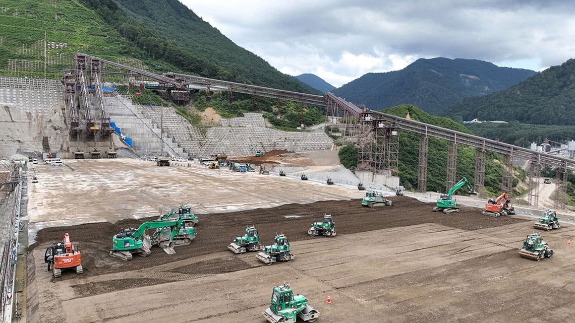 成瀬ダムの工事現場で稼働するダンプトラックやブルドーザー