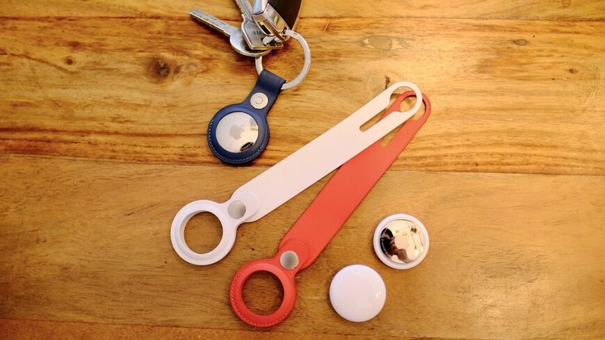 AirTagとアップル純正アクセサリー。持ち物に取り付ける、直径約3cmの丸いボタンのようなデバイスだ（筆者撮影）