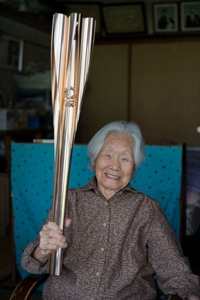 104歳の時には、東京五輪の聖火リレーのランナーにも選ばれ、息子さんと二人三脚で務めた。記念にもらったトーチはシツイさんの身長の半分以上！ その重さに驚いたという（撮影：栗栖誠紀）